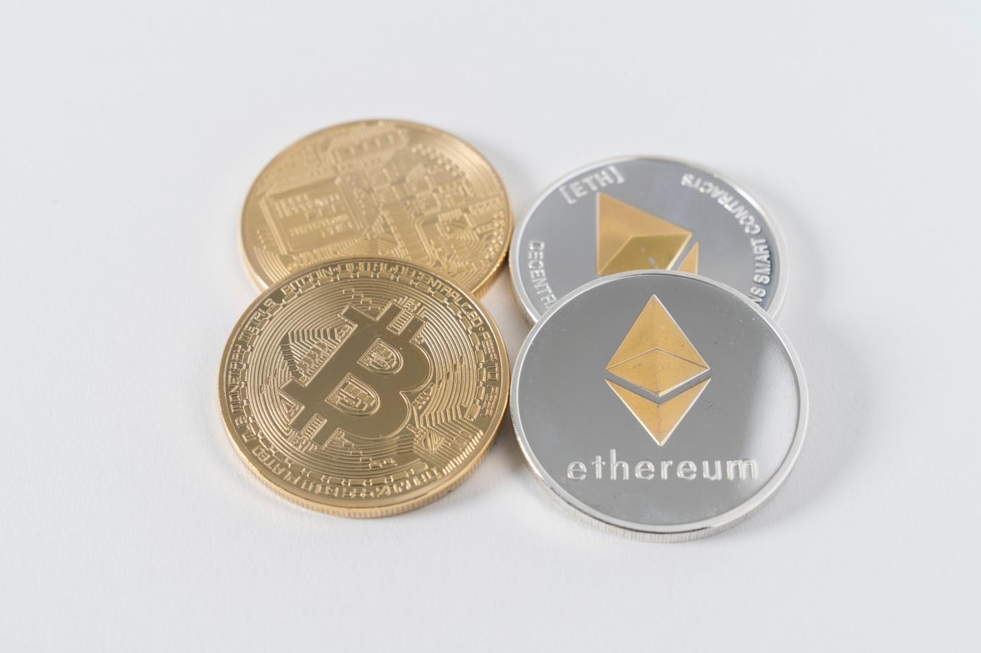 Two Bitcoins and two Ethereum digital coins can be seen in the image. 